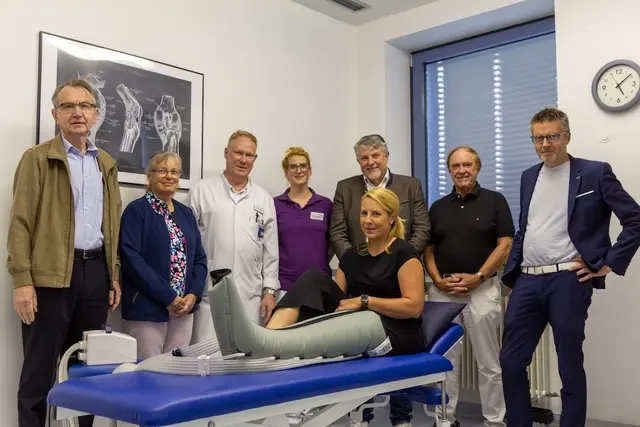 Auf dem Bild werden gezeigt: Die Leiterin der Physiotherapie der Wertachkinik Bobingen, Michaela Schildhauer (Mitte) zeigte den beiden ehemaligen Anästhesie-Chefärzten und jetzigen Vorstandsmitgliedern des Fördervereins der Wertachklinik Bobingen, Dr. Hans-Eberhard Zank (1.v.li) und Dr. Edwin Krebs (2.v.re) sowie ihrem Vorstandskollegen und aktuellen Chefarzt der Unfallchirurgie und Orthopädie, Dr. Jochen Wittich (3.v.li), der Patientenfürsprecherin und ehemaligen leitenden Oberärztin Dr. Marga Dorfmiller-Kapetanopulos (2.v.li) sowie dem ehemaligen Bobinger Bürgermeister und Vereinssitzender Bernd Müller (3.v.re) und Klinikvorstand Martin Gösele (1.v.re) das neue Lymphdrainage-Massagegerät im Wert von knapp 3000 Euro, das der Förderverein der Wertachklinik Bobingen gespendet hat. Martina Strehler (vorne), seit vielen Jahren im Vorstand des Fördervereins, demonstrierte die Beinmanschette, mit dem das Gerät eine Lymphdrainage durchführt.