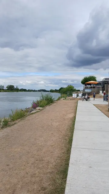 Links im Bild die Maas in Arcen (NL) Rechts im Bild neuer Gehweg aus fertig gegossenen Betonplatten. Aktuell wird daran gearbeitet, sodass ein großer Teil der Uferzone abgesperrt ist und nicht betreten werden kann. | Foto: Siegmund Walter, 07.08.2026