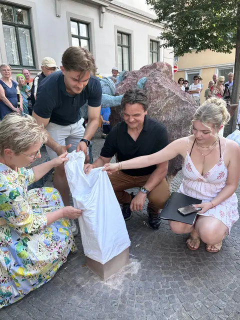 Familie Seel - Sponsoren des Kunstwerks - enthüllt den Stein mit Informationen zum "Wir-Projekt".