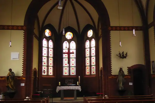 Blick aus dem Kirchenraum zum Chor. Die Standbilder davor zeigen links Josef von Nazareth, rechts die Heilige Maria.