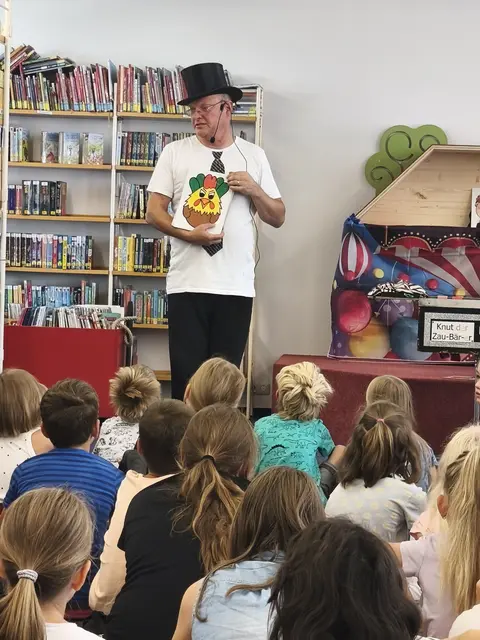 Zauberer vor Kinder im Publikum.