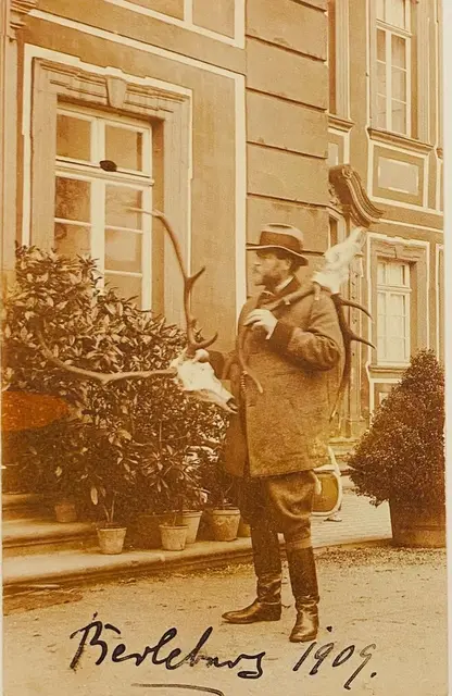 Der Jagdgast Graf Alfred von Schmising-Kerssenbrock mit Jagdtrophäen vor dem Schloss Berleburg 1909