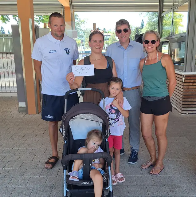 Das Foto zeigt Freibadleiter Sebastian Wagner (links) und Ersten Bürgermeister Martin Brenner (2.v.r.) mit Familie Nowak-Dietze.