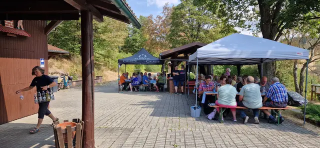 Vor der Grillhütte unter schattigen Plätzen und blauem Himmel sorgt die Schatzmeisterin Sylvia Müller für Nachschub der Getränke.