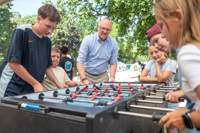 Oberbürgermeister Sören Link ist begeistert von den Angeboten der Stadtranderholung. Hier kickert mit Kindern auf der Abenteuerfarm Robinson in Friemersheim.   
Foto: Tanja Pickartz / Stadt Duisburg
