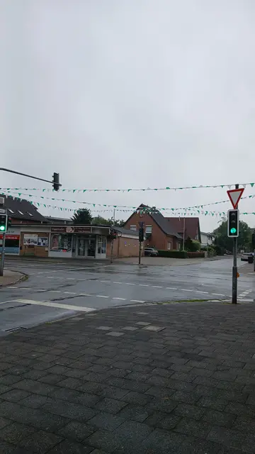 Schützenfest-Girlanden über der Straßenkreuzung Feldstraße/Tannenstraße in Wesel-Obrighoven. Weiß Grüne Girlanden (Wimpelketten) befestigt am Ampelmast. | Foto: Siegmund Walter, 18.08.2026