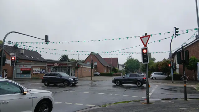 Schützenfest-Girlanden über der Straßenkreuzung Feldstraße/Tannenstraße in Wesel-Obrighoven. Weiß Grüne Girlanden (Wimpelketten) befestigt am Ampelmast. | Foto: Siegmund Walter, 18.08.2026