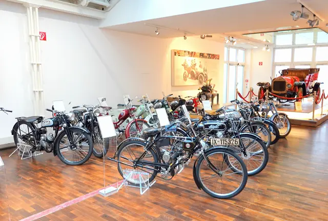 Fahrräder mit Motor und leichte Motorräder. Im Hintergrund der Miele K 3.
