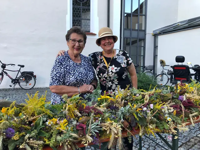 Foto: .Stolz sind diese beiden Frauen auf die bunten Kräuterbüschel, die zur Ehre Mariens gebunden wurden.Diese warten nun auf ihre Segnung und dürfen dann gegen eine Spende mit nach Hause genommen werden.