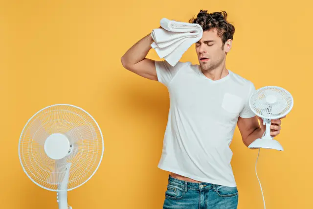 Mann mit Handtuch und Ventilator | Foto: LIGHTFIELD STUDIOS - adobe.stock.com