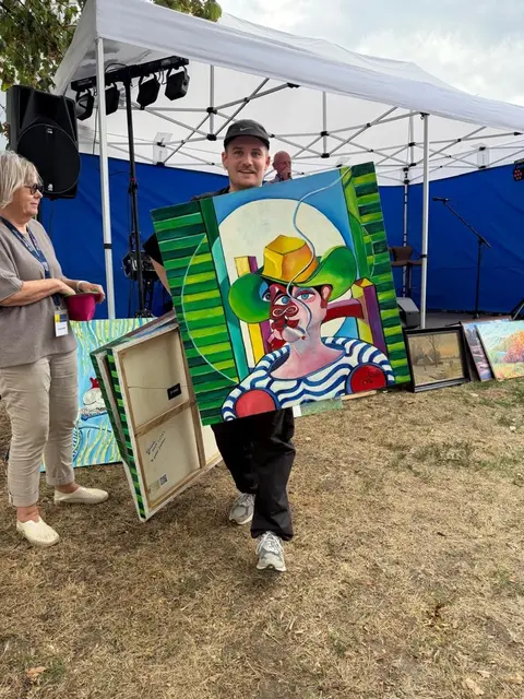 Mülheimer Nachwuchskünstler Malte Gemlau mit seinem ersteigerten Kunstwerk des Malers Reinhild Koolen (1943-2013), der zuletzt in der Malgruppe Kunstfeld aktiv war.