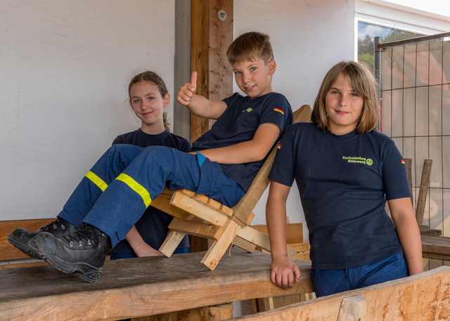 THW-OV Friedberg - Ferienprogramm 2026 - „Wir bauen viel mit Holz, und dürfen mit technischem Gerät arbeiten“ so die Jugendliche. „Zuletzt haben wir aus Holz und Jute unsere eigenen Liege-Stühle gebaut.“ Stolz zeigen uns Lara, Johanna und Florian das gefertigte Werkstück. | Foto: FSeventfoto