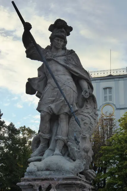 Der Georgsbrunnen aus dem Jahr 1738 steht auf dem Burggelände. Die Brunnenfigur des Heiligen Georg wurde von dem Mainzer Bildhauer Burkard Zamels im Stile des Barock geschaffen. Die Figur, die heute den Brunnen schmückt, ist eine Kopie. Das Original befindet sich im nahegelegenen Wetterau-Museum. Rechts im Bild zeigt sich der Turm der Burgkirche.