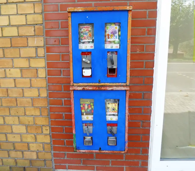Alter, funktionstüchtiger Kleinspielzeug-Warenautomat, gefüllt mit bunten Sammelfiguren. 
Standort: Wesel-Büderich | Foto: Siegmund Walter, 05.09.2026, 16:12 Uhr