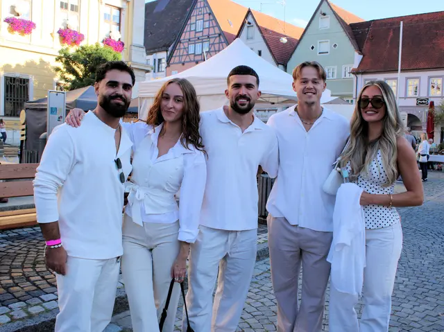 Besucher in weiß genießen den lauen Sommerabend