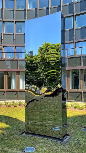 Fünf glänzend polierte Stelen (2013) von dem Künstlerehepaar Stefanie Schenk-Busse und Björn Busse. Die Installation trägt den Titel "Im Aufbruch".   Sie bildet einen Kontrapunkt zur Architektur. Die Aufstellung im Halbkreis nimmt die räumliche Vorgabe auf.

 | Foto: copyright Margot Klütsch