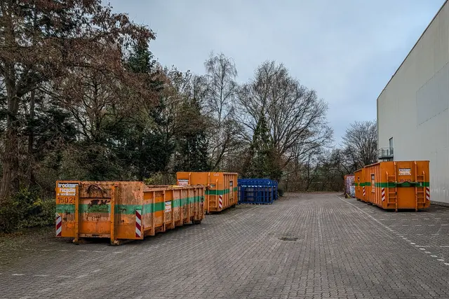 Industrieabfallcontainer neben Lagerhalle im Winter, mit Schnee am Boden | Foto: Pexels | El Jundi, @talal