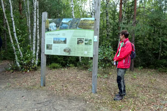 Wanderführerin Ines Holbein an einer Infotafel am Wanderweg Spur der Steine