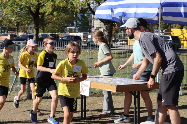 Einige Athletinnen und Athleten der U10 an einer Gummiausgabestation - die Stationsbetreuer feuern die Athleten kräftig an.  | Foto: M. Linder