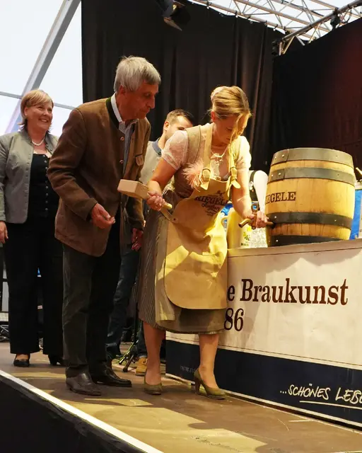 Susanne Olita, Erste Bürgermeisterin, sticht das Bierfass zur Eröffnung der Kirchweih Gersthofen 2026 an. Melanie Schappin, Stadträtin und Marktreferentin, Dr. Sebastian Priller, Riegele, und Susanne Olita, Erste Bürgermeisterin.  | Foto: Stadt Gersthofen (Kai Schwarz)