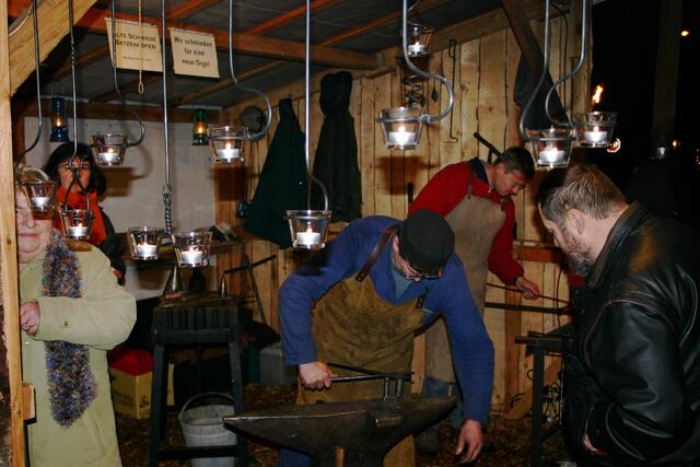 Robert Sailer arbeitet am Amboß unter dem gespannten Blick von Manfred Hainke