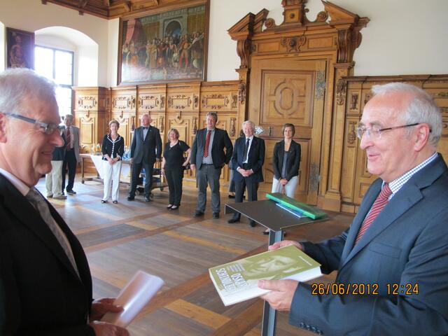 Prof. Skotnicki überreicht dem Bürgermeister von Augsburg, Herrmann Weber sein Buch in deutscher Sprache, dahinter Regina  Pemper, die Präsidentin der Universität Frau Prof. Doering-Manteuffel, Dr. Nikolaus Hueck, Friedenspreisträger Helmut Hartmann und die persönliche  Referentin der Uni-Präsidentin, Anne Ruile.