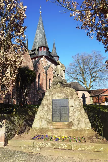 Das Ehrenmal für die Gefallenen der Weltkriege bei der katholischen Kirche St. Cyriakus in Bauerbach, dessen Chorturm im 15. Jahrhundert gebaut wurde. Bauerbach ist ein Stadtteil von Marburg im Landkreis Marburg-Biedenkopf (Hessen). 