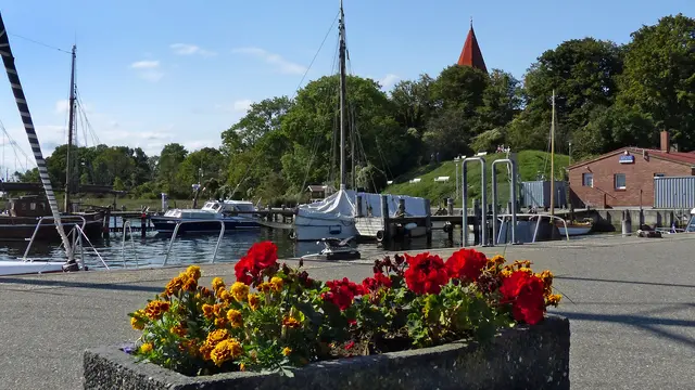 Auf der Insel Poel ist am Hafen von Kirchdorf der beruhigende Effekt der maritimen Landschaft zu spüren. Von der Uferpromenade reicht der Blick zum markanten Turm der Backsteinkirche aus dem 13./14. Jahrhundert, der die Wallanlagen überragt. Der weithin sichtbare Kirchturm gehört als einstiges Schifferzeichen zur unverkennbaren Silhouette der Ostseeinsel. Foto: Helmut Kuzina