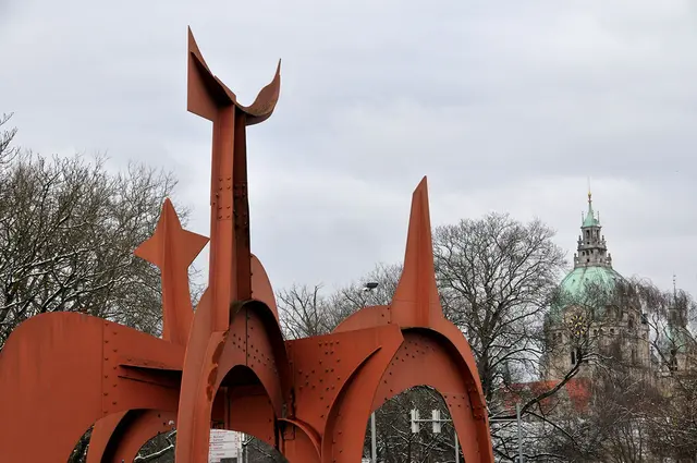Alexander Calder schuf die Skulptur im Vordergrund. Titel: der "Hellebardier".Übrigens gab Hannover dem Kunstwerk ursprünglich den Namen  "Guadeloupe". Da wurde einfach eine Ortsangabe mit dem Titel verwechselt. Tja, moderne Kunst ist nicht immer einfach.