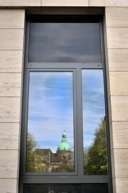 Die Kuppel der Deutschen Bank spiegelt sich in einer Fensterscheibe