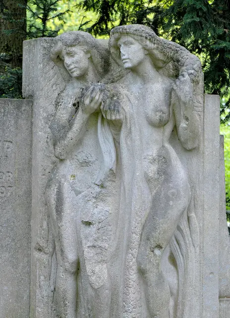 Die beiden Damen aus Muschelkalk gehören zum Julius-Trip-Denkmal im Maschpark aus dem Jahr 1910. Ursprünglich war es ein Brunnen, der aber im 2. Weltkrieg beschädigt wurde. Bie der Wiederherstellung wurde dann auf die Wasserspiele verzichtet.
