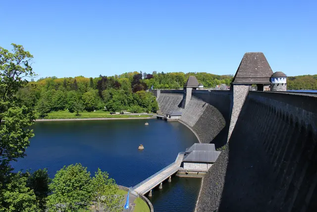Die Luftseite der Möhnesee-Staumauer (die dem Wasser abgewandte Seite) bietet einen spektakulären Blick auf die monumentale Bruchsteinarchitektur der 650 Meter langen und rund 40 Meter hohen Mauer. Besonders markant ist das unterhalb der Mauer liegende Ausgleichsbecken und die umliegende Parklandschaft des Ortsteils Günne. | Foto: Volkmar Brockhaus