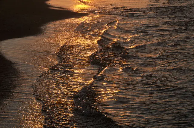 Die untergehnde Sonne verwandelt den Strand und das Meer in eine unwirkliche Landschaft