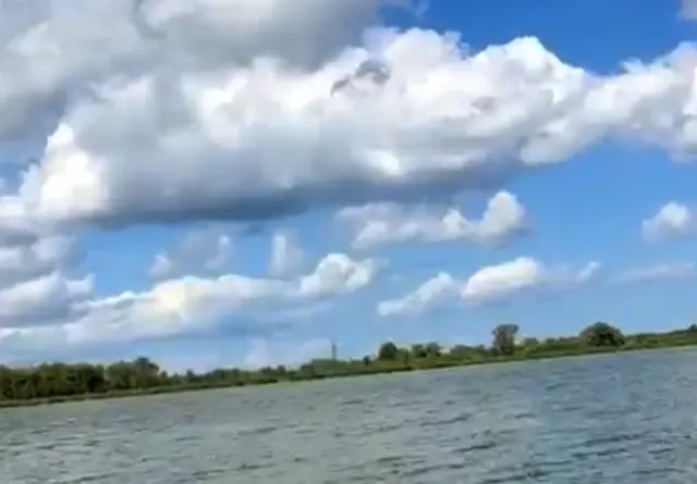 Ein faszinierendes Spiel aus Blautönen, dichten Wolken und ruhiger Wasserfläche.