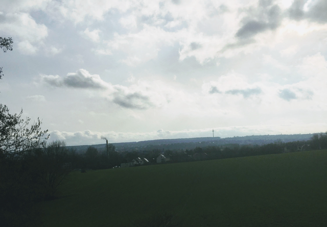 Gedeckte Farben, ziehende Wolken und eine weite Landschaft – ein friedlicher Blick in die Ferne.